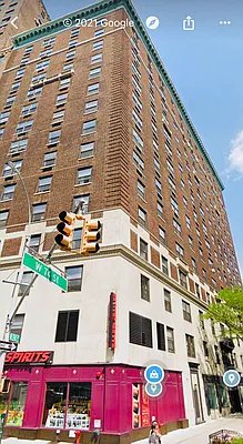 Front view of a multi-story brick building with retail space on the ground floor.