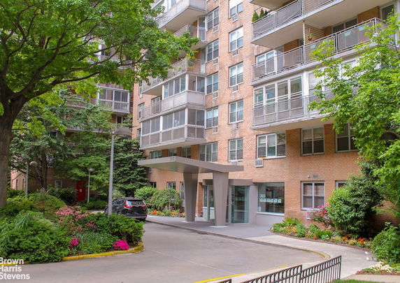 Front view of a multi-story apartment building with large windows and balconies.