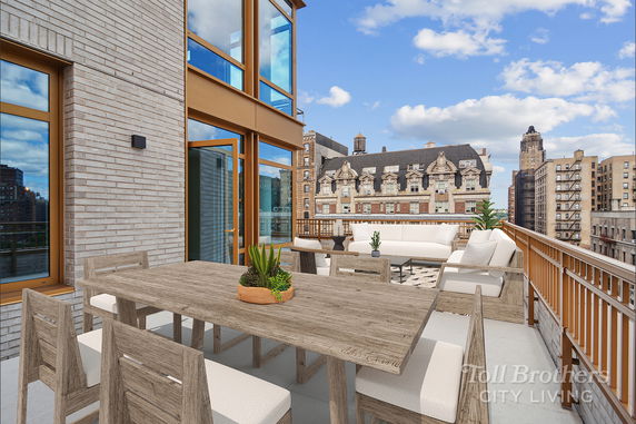 Rooftop terrace with seating area and table.