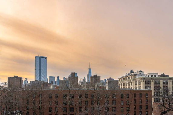 Skyline view of a city with tall buildings at sunset.