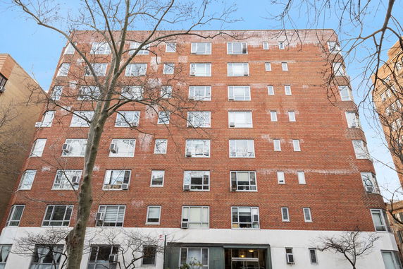 Front view of a multi-story brick building with numerous windows.