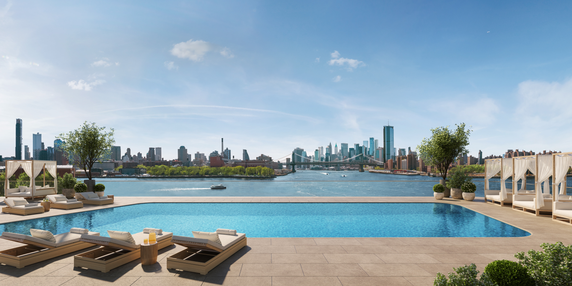 Panoramic view of a swimming pool with city skyline in the background.