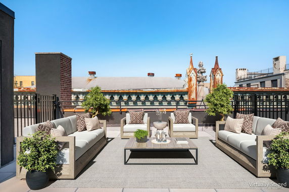 Rooftop with outdoor seating and decorative plants.
