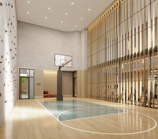 Indoor basketball court with climbing wall and seating area.