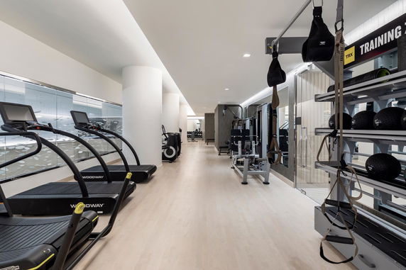 Interior of a modern gym with treadmills, exercise equipment, and training accessories.