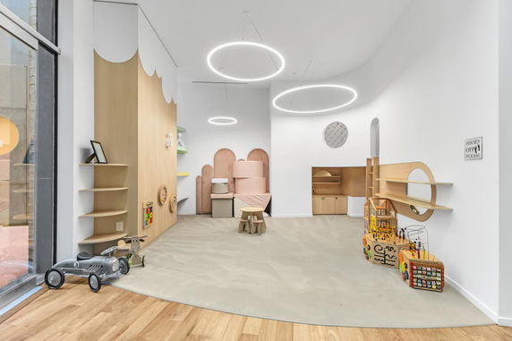 Indoor children's play area with toys and circular ceiling lights.