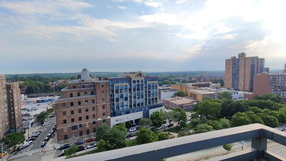 Panoramic view of cityscape with multiple buildings and greenery.