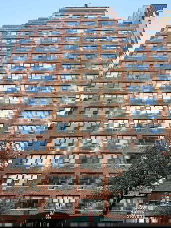 Front view of a multi-story brick building with numerous windows.