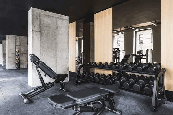 Interior view of a gym with weights and exercise benches.