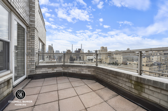 Rooftop terrace with a view of a city skyline.