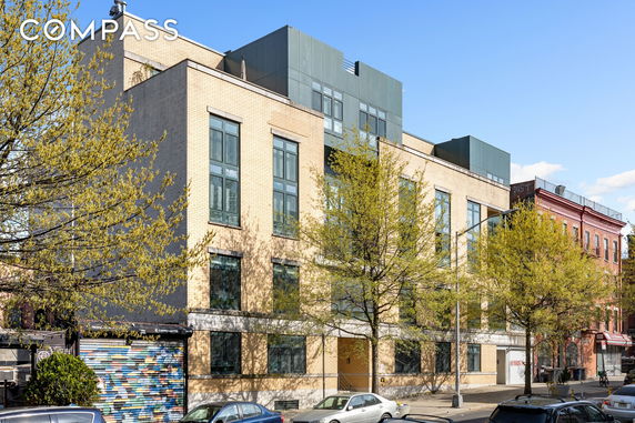 Front view of a modern multi-story building with large windows.