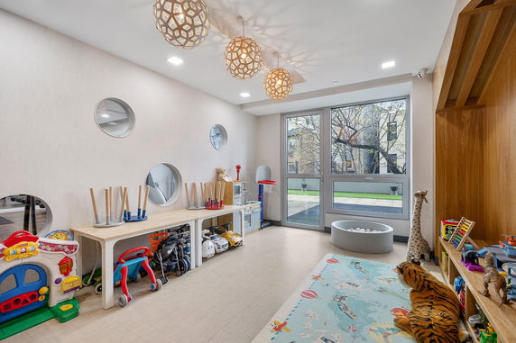 Indoor play area with toys and play equipment.