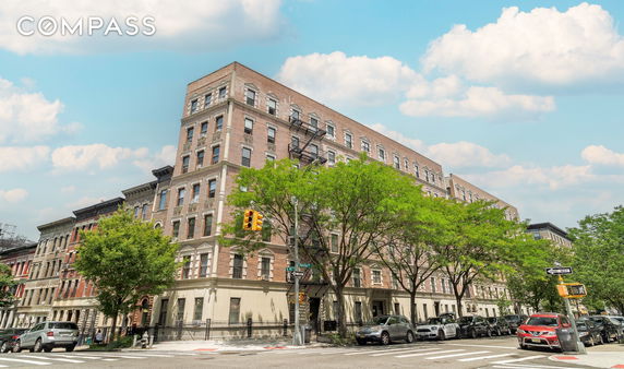 Front view of a multi-story brick building on a street corner.