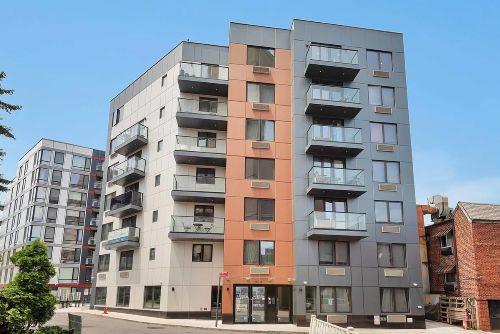 Front view of a multi-story apartment building with balconies.