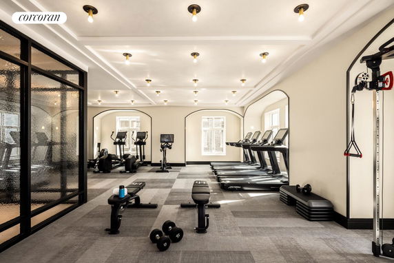 Indoor gym area with treadmills, benches, and exercise equipment.