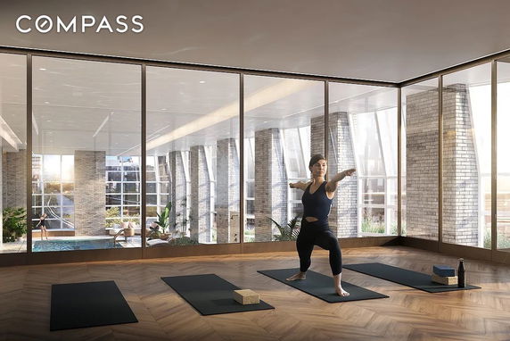 Interior view of a modern gym area with yoga mats and a pool in the background.