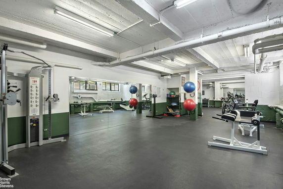 Indoor gym area with exercise equipment and mirrors.