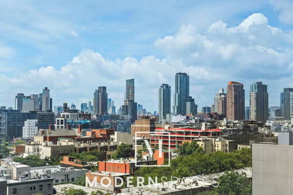Panoramic view of a city skyline with high-rise buildings and blue sky.