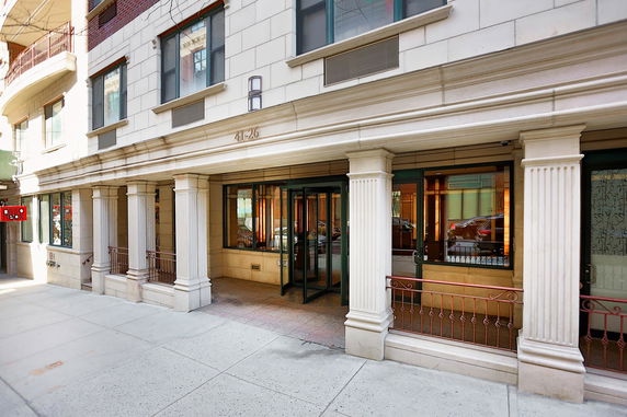 Front view of a multi-story building with columns and large windows.