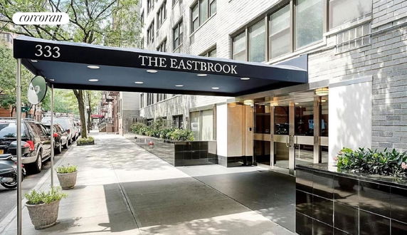 Entrance view of an apartment building with a canopy labeled 'The Eastbrook' and street number '333'.