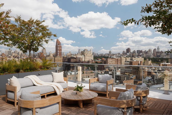 Rooftop terrace with comfortable seating and cityscape view.