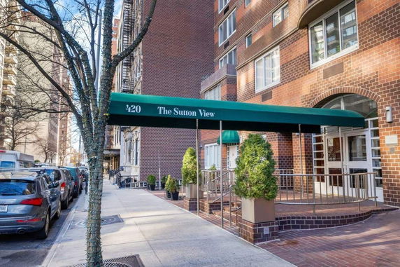 Front view of a multi-story brick building with a green canopy over the entrance.