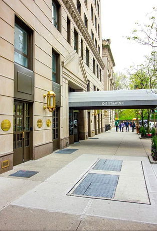Front view of a multi-story building at 1049 Fifth Avenue with a sidewalk entrance.