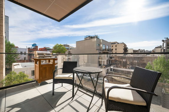 Balcony view overlooking urban residential buildings with a table and chairs.