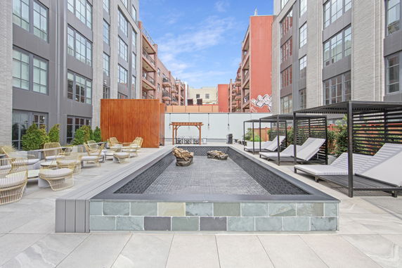 Outdoor area with a modern pool surrounded by lounge chairs and seating.