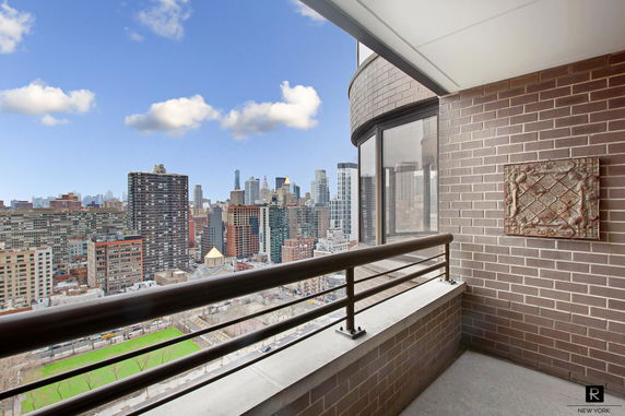 Balcony with a view of a city skyline.