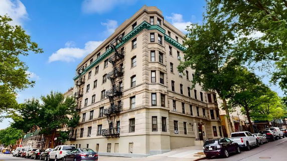 Front view of a multi-story residential building with fire escapes.