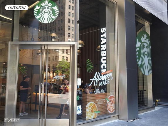 Front view of a commercial building with large glass doors and a Starbucks logo.