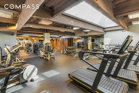 Interior view of a gym with various fitness equipment and treadmills.