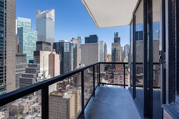 Panoramic view of cityscape with multiple skyscrapers seen from a balcony.