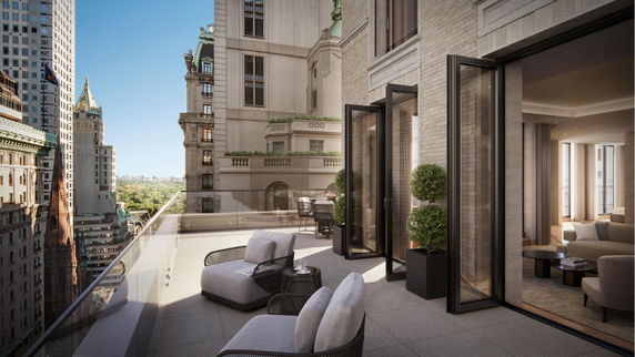 Balcony view of city buildings with a spacious seating area.