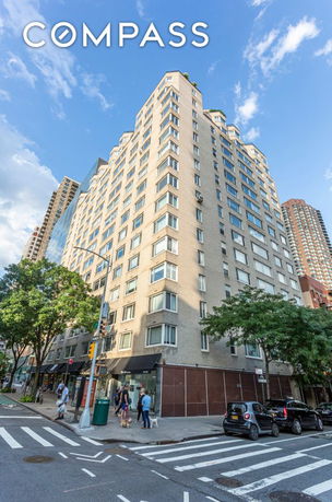 Front view of a multi-story apartment building on a street corner