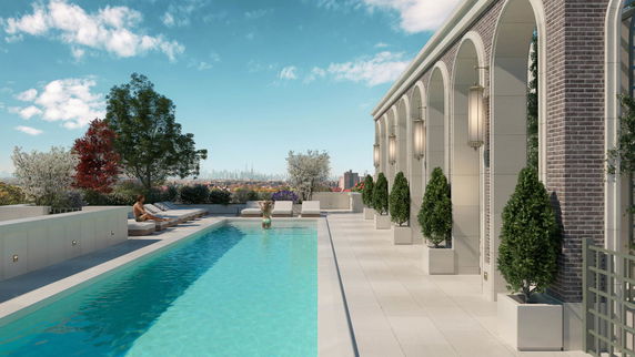 Rooftop swimming pool with surrounding lounge chairs and urban skyline view.