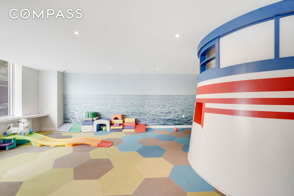 Indoor children's play area with vibrant flooring and play equipment.