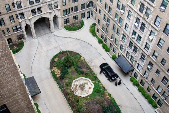 Aerial view of a building courtyard with a driveway and a car parked next to the entrance.