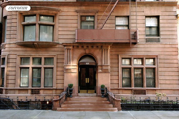 Front view of a multi-story building with a central entrance and large windows.