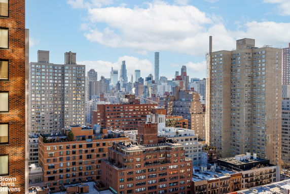 Panoramic view of city buildings under a partly cloudy sky.