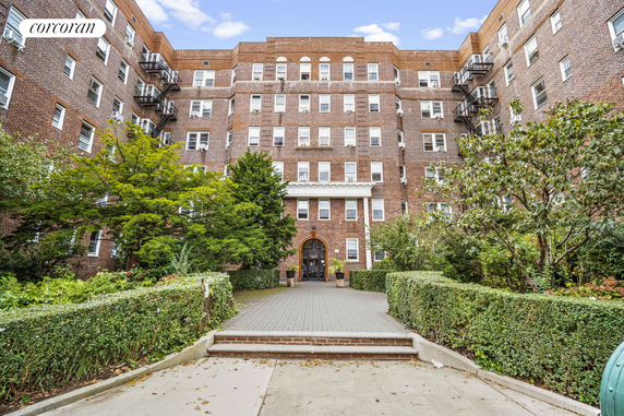 Front view of a multi-story brick apartment building.