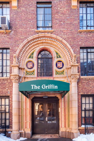 Front view of a brick building with an ornate arch above the entrance labeled 'The Griffin'.