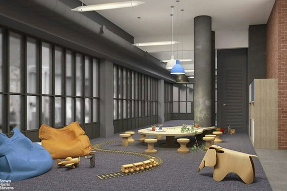Indoor play area with bean bags, toy train, and activity table.