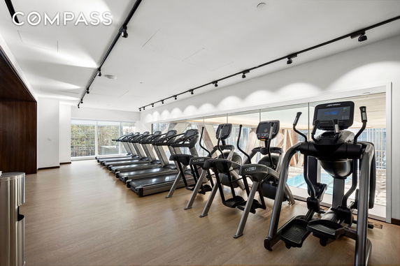 Interior view of a gym room with exercise equipment and treadmills.
