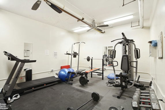 Indoor gym area with exercise equipment, including treadmill, weight bench, and gym machine.