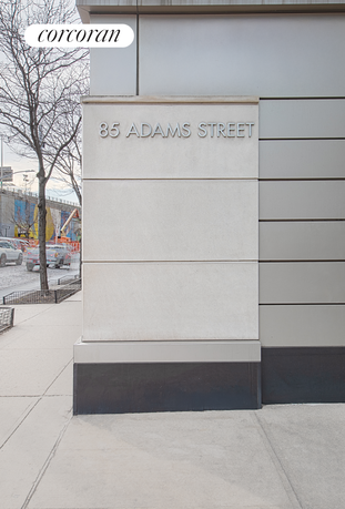 Corner view of a building with the address '85 Adams Street' displayed on a wall.