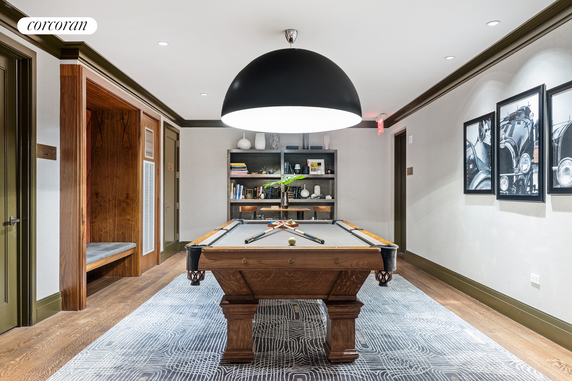 Interior room with a billiards table, modern lighting, and framed artwork on the walls.
