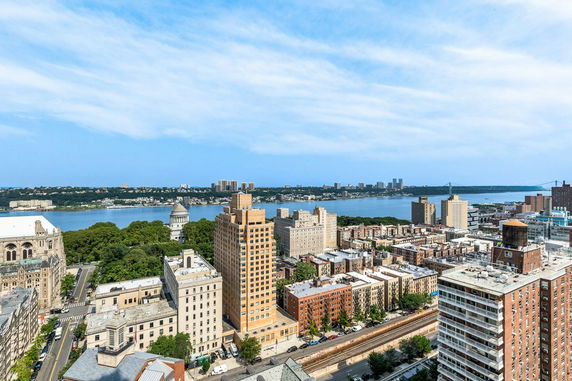 Panoramic view of a cityscape with a river and distant buildings.