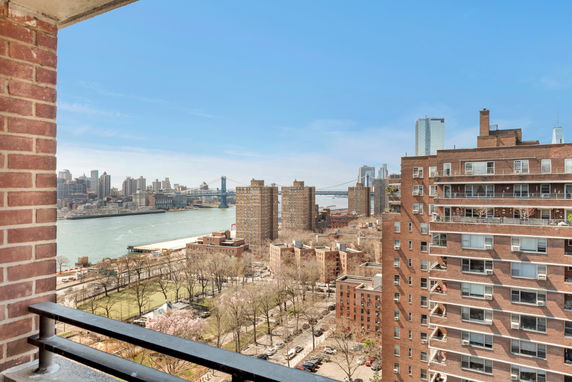 Panoramic view from a building showing a cityscape, river, and bridge.